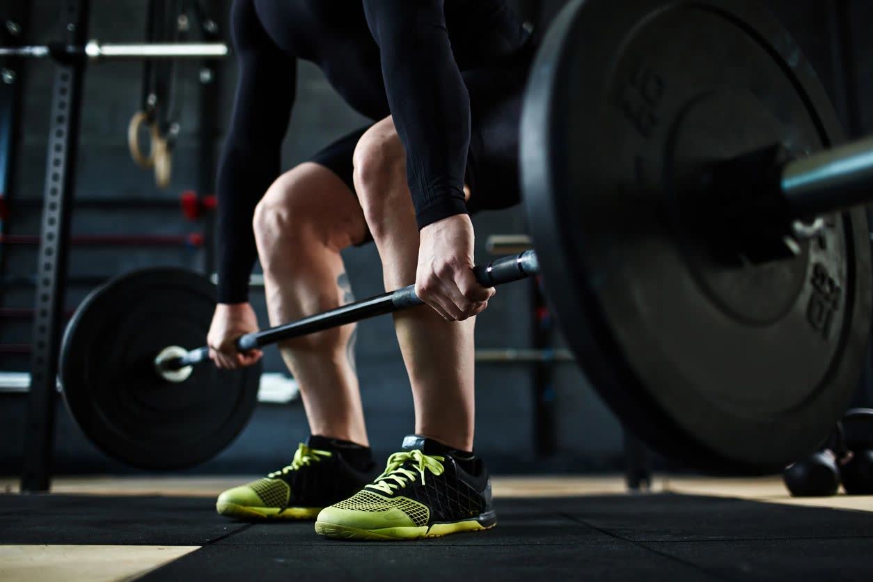Close-up of a lifter gripping a loaded barbell, ready to deadlift