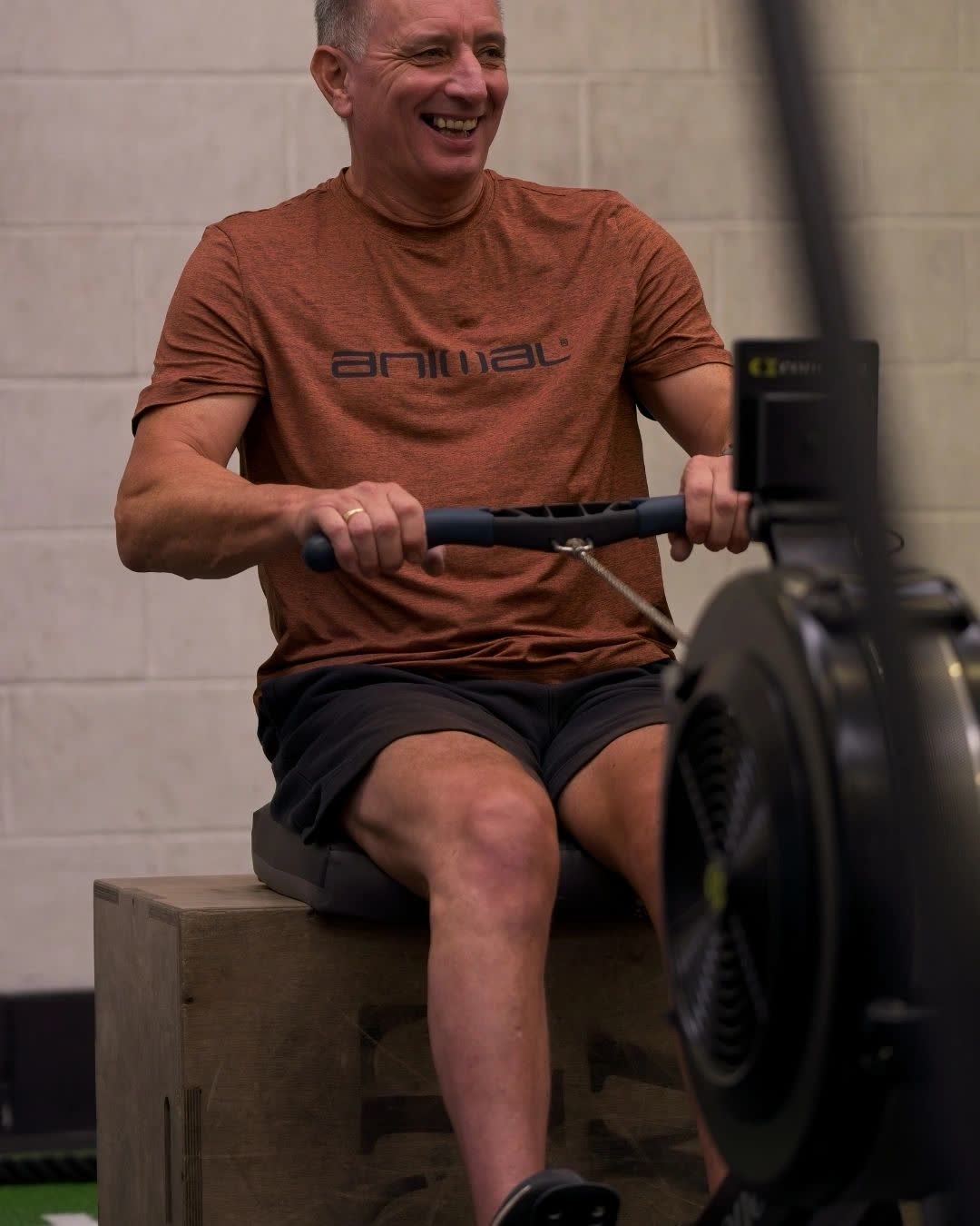 An adaptive athlete smiling on the rowing machine