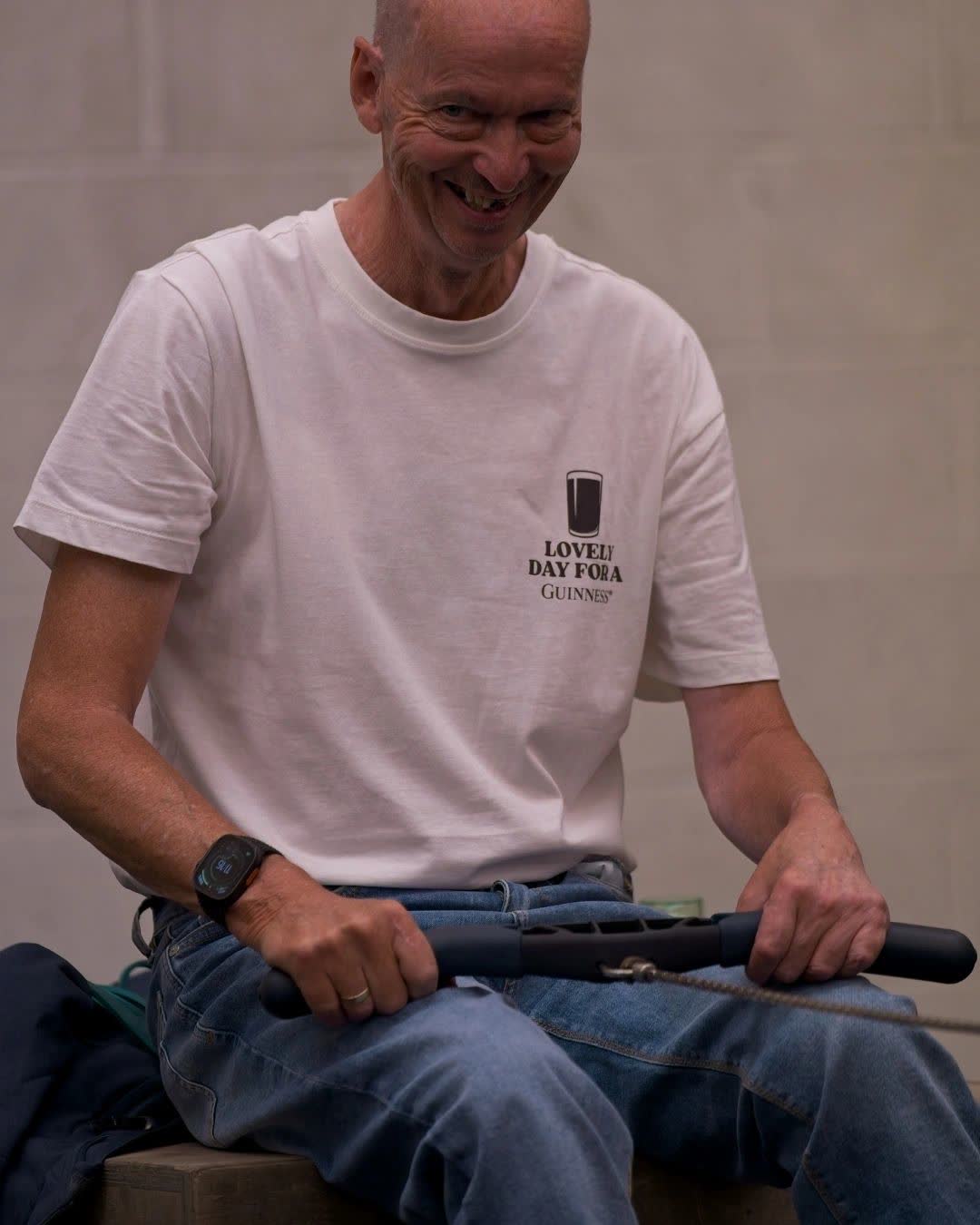 An adaptive athlete smiling during a seated exercise
