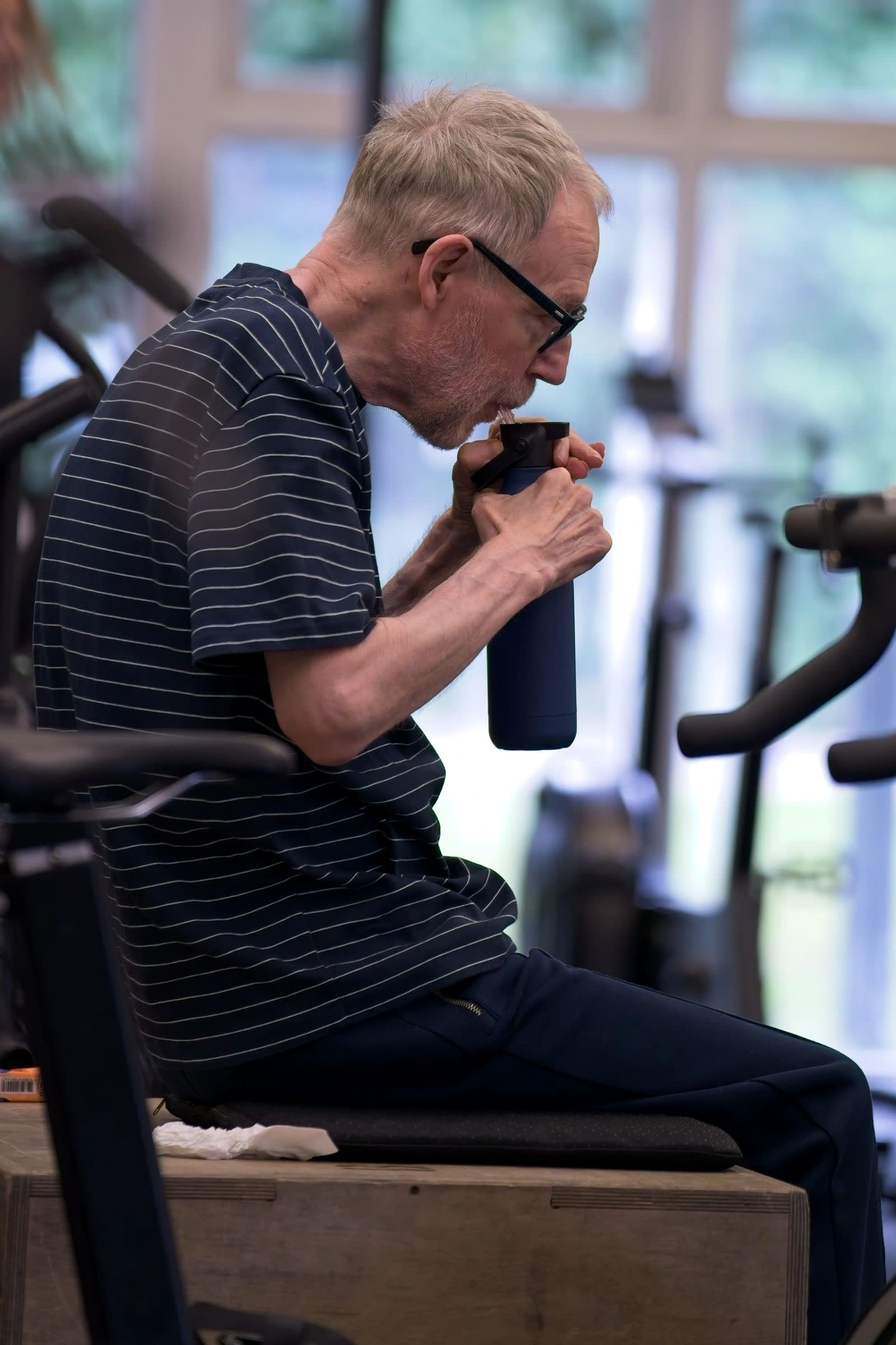 Nick, an adaptive member, taking a drink between exercises