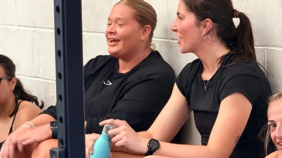 Two members laughing together between exercises