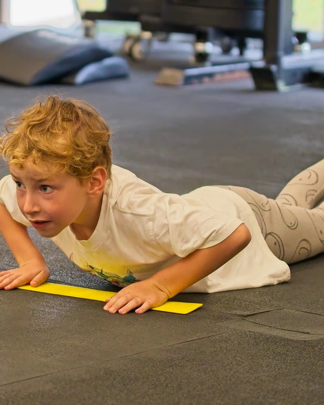 A boy doing a push-up in a CrossFit Kids class