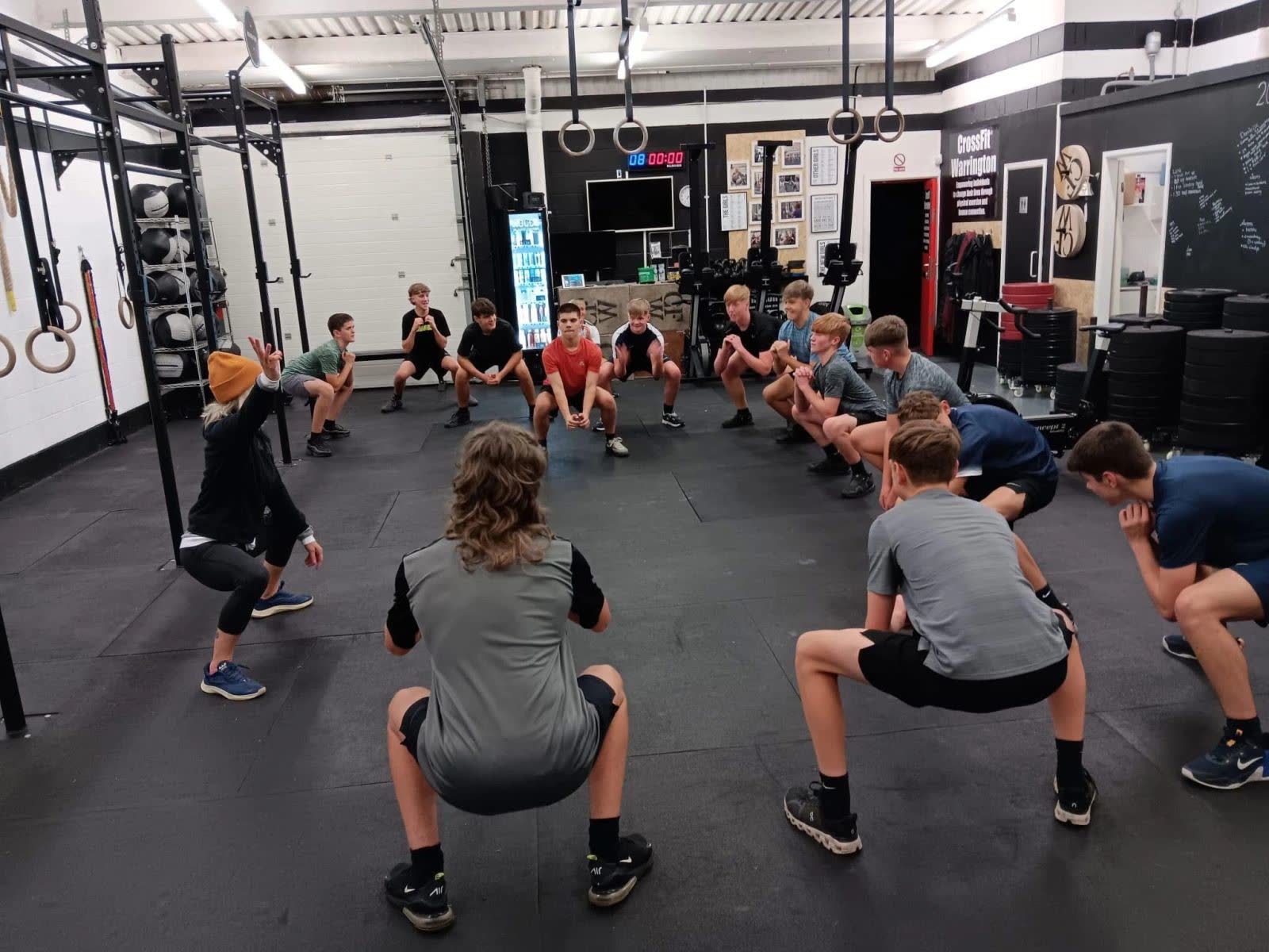 A youth team squatting together in the gym