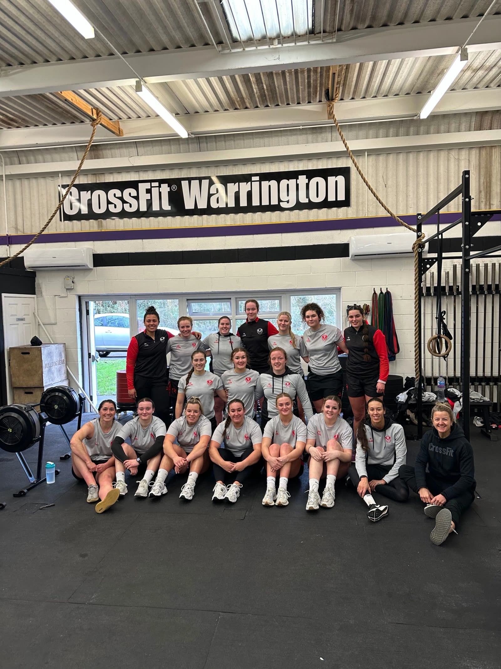 A women's team sitting together under the CrossFit Warrington sign