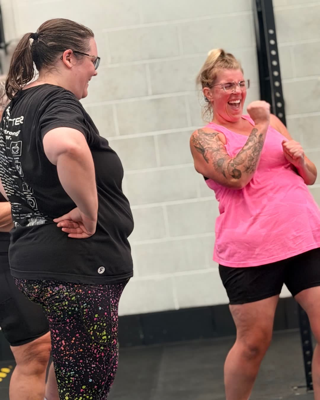 Two members laughing together in the gym