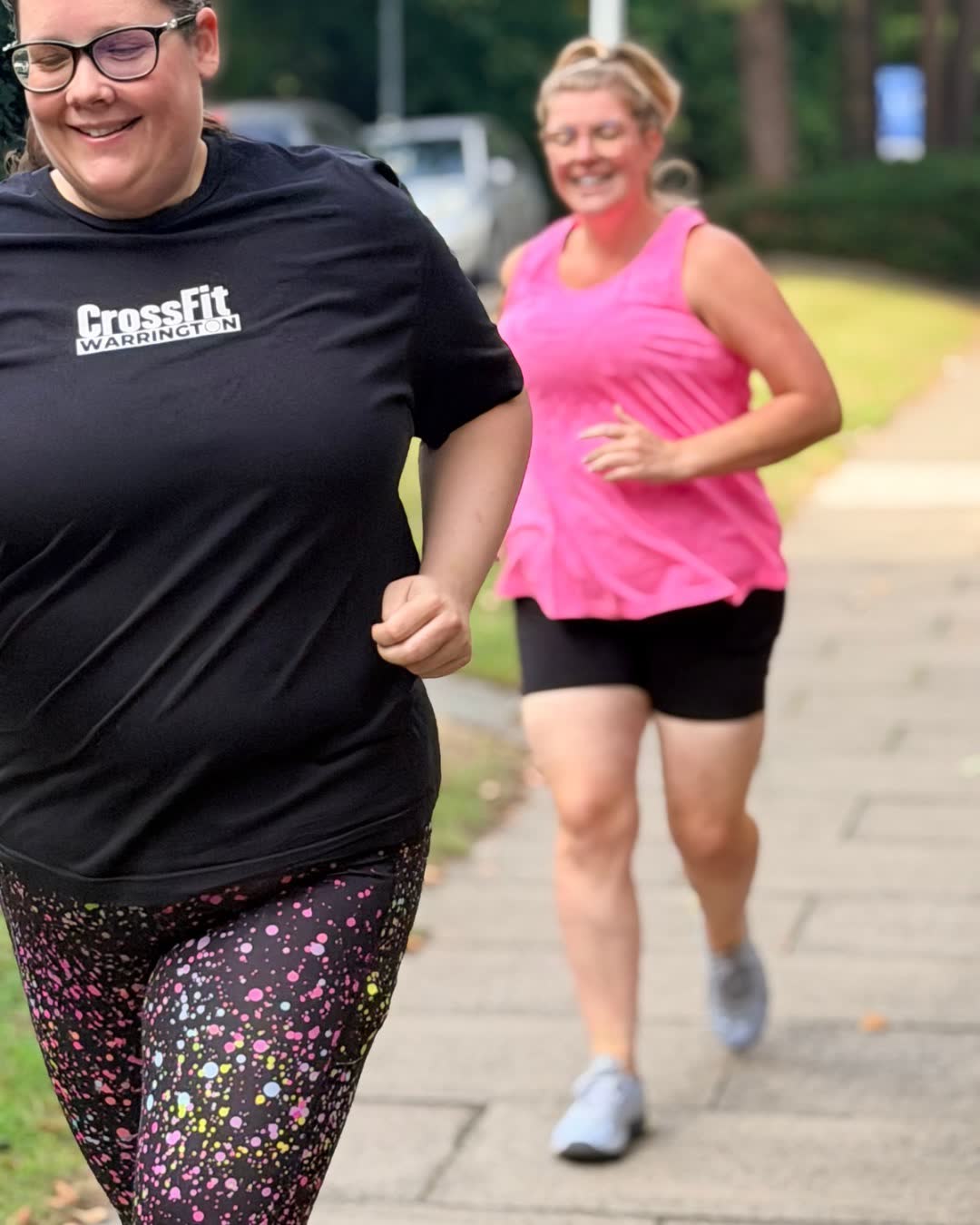 Two members running outside, one in a CrossFit t-shirt