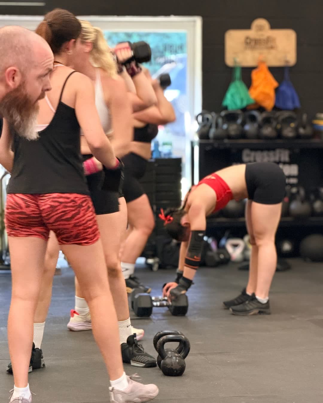 A class training with dumbbells and kettlebells in the gym
