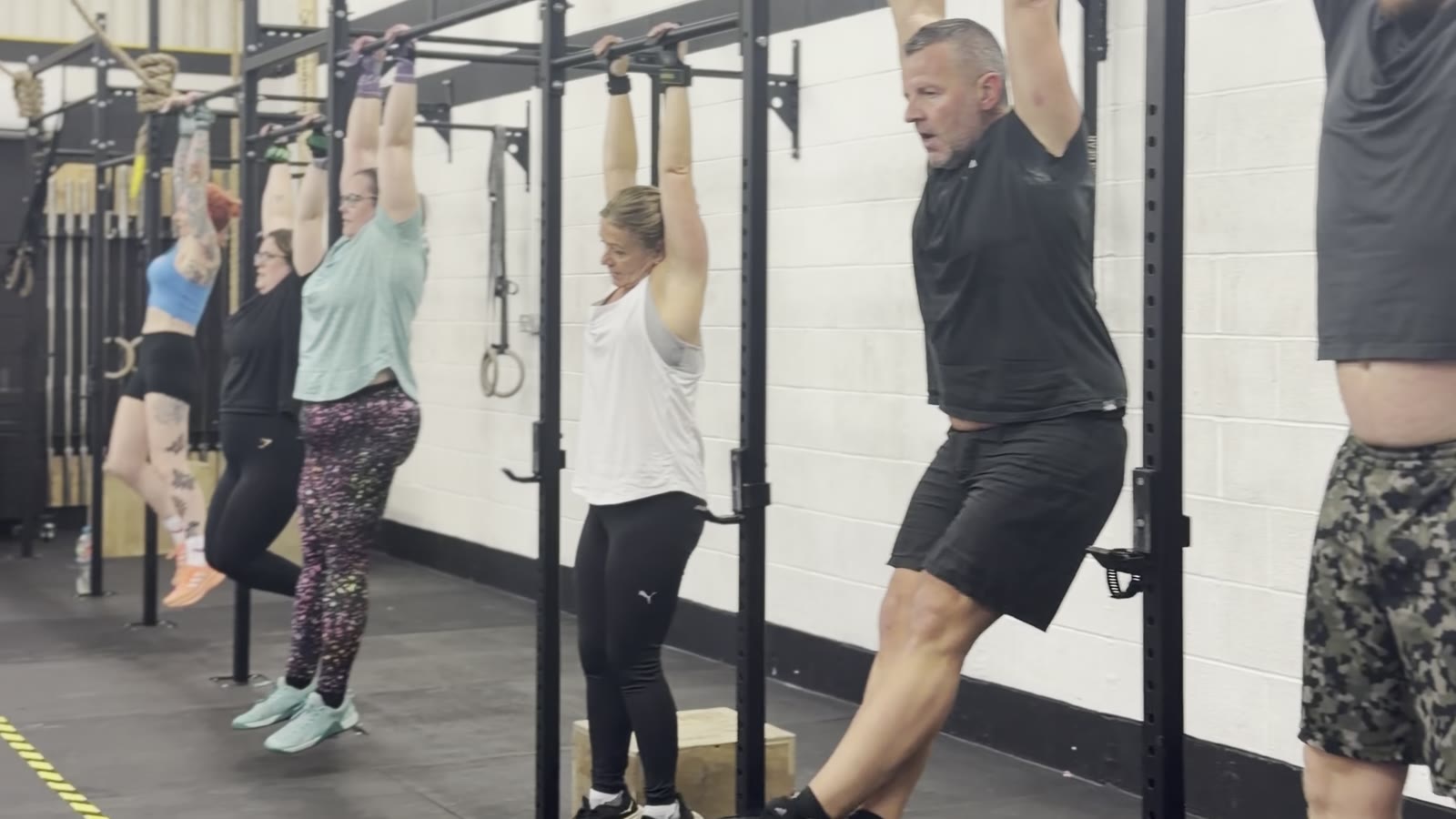 Members doing hanging knee raises on the pull-up rig at CrossFit Warrington